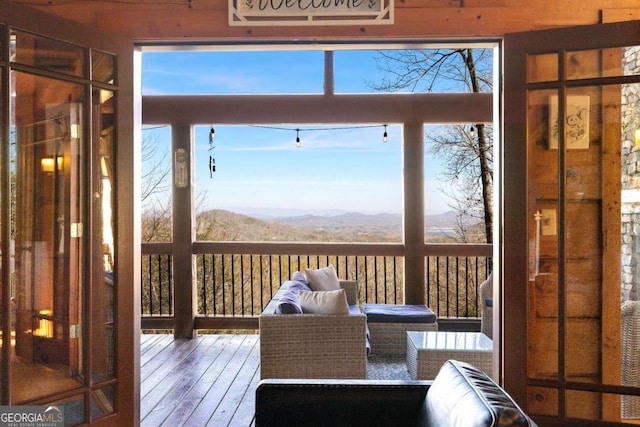 sunroom / solarium with a healthy amount of sunlight and a mountain view