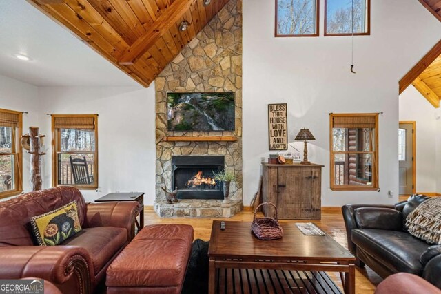 living room with beamed ceiling, high vaulted ceiling, light hardwood / wood-style floors, and wooden ceiling