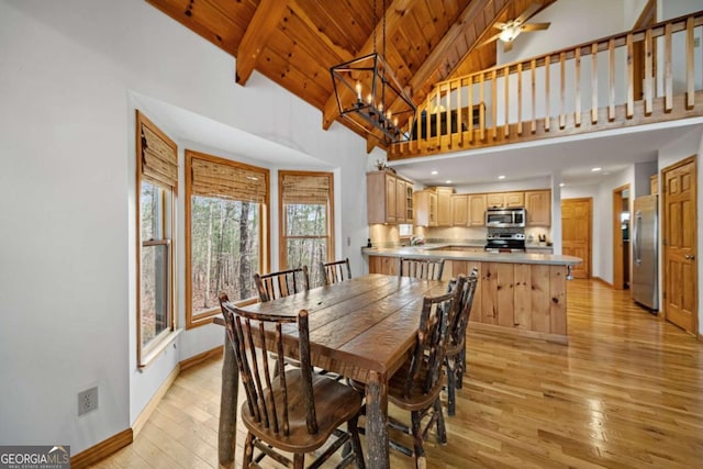 dining space with an inviting chandelier, high vaulted ceiling, light hardwood / wood-style floors, wooden ceiling, and beam ceiling