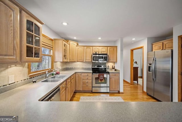 380 Oak Ridge Way, Morganton, GA 30560 - kitchen featuring appliances with stainless steel finishes, a sink, light wood finished floors, glass insert cabinets, and decorative backsplash