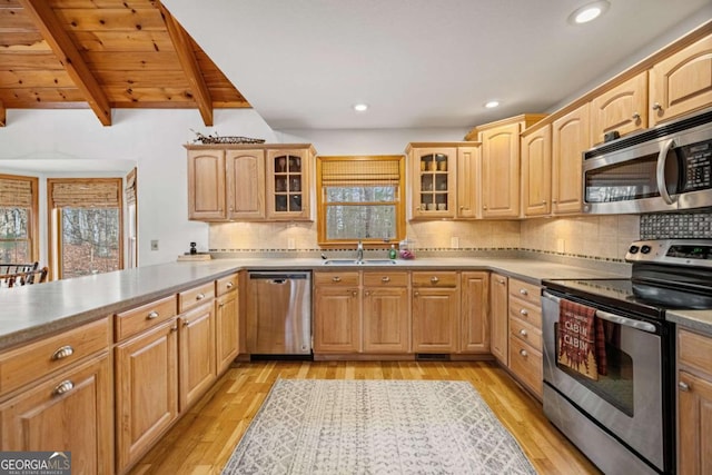 kitchen with sink, backsplash, stainless steel appliances, light brown cabinets, and light wood-type flooring