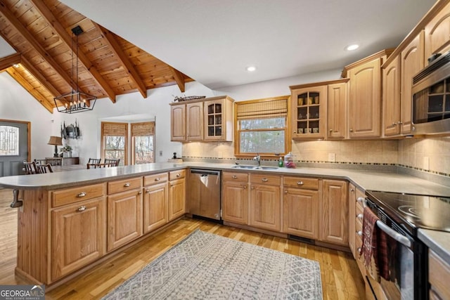 kitchen featuring sink, lofted ceiling with beams, stainless steel appliances, and kitchen peninsula