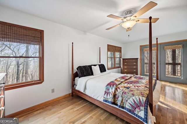 bedroom with ceiling fan, light hardwood / wood-style floors, and multiple windows