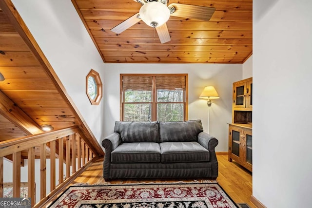 living room featuring vaulted ceiling, light wood-type flooring, ceiling fan, and wood ceiling