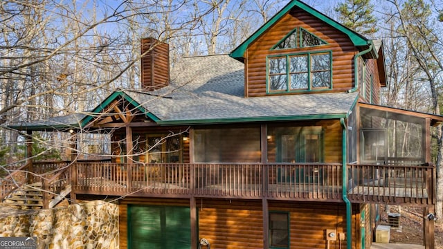 rear view of property with a wooden deck and a sunroom