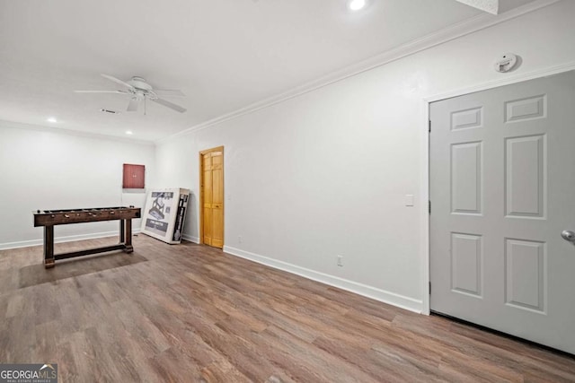 rec room with hardwood / wood-style floors, crown molding, and ceiling fan