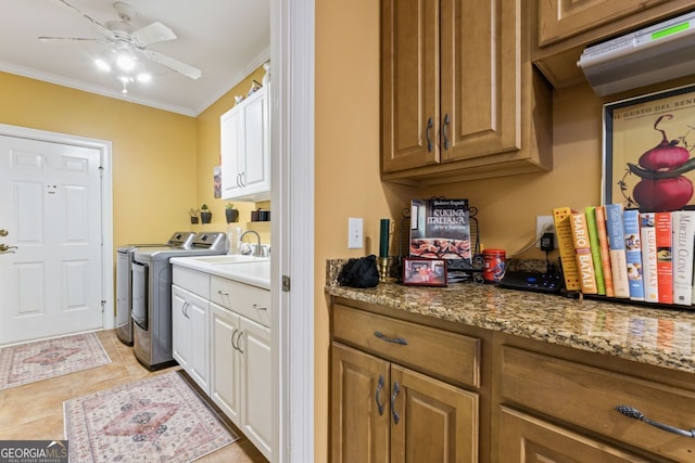 256 Allie Dr, Mcdonough, GA 30252 - laundry area featuring washing machine and dryer, crown molding, a ceiling fan, light tile patterned floors, and cabinet space