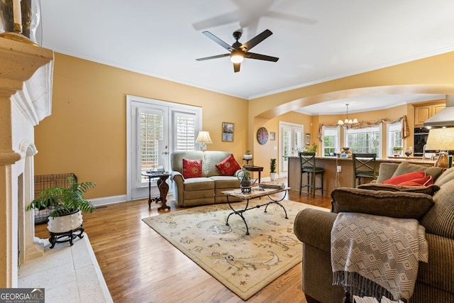 256 Allie Dr, Mcdonough, GA 30252 - living area featuring ornamental molding, arched walkways, ceiling fan with notable chandelier, and light wood finished floors