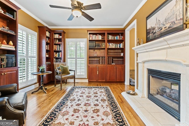 256 Allie Dr, Mcdonough, GA 30252 - sitting room with ornamental molding, a glass covered fireplace, light wood-style floors, and a wealth of natural light