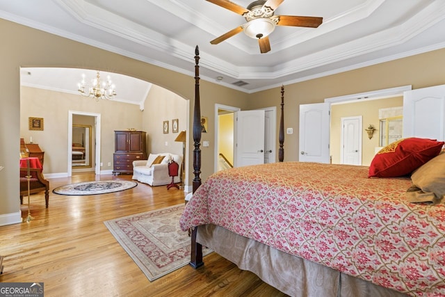 256 Allie Dr, Mcdonough, GA 30252 - bedroom featuring a tray ceiling, light wood finished floors, baseboards, arched walkways, and ornamental molding
