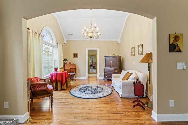 256 Allie Dr, Mcdonough, GA 30252 - living area with a chandelier, crown molding, baseboards, wood finished floors, and arched walkways