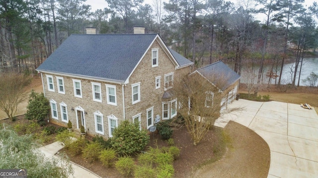256 Allie Dr, Mcdonough, GA 30252 - exterior space featuring a water view, driveway, a shingled roof, and a chimney