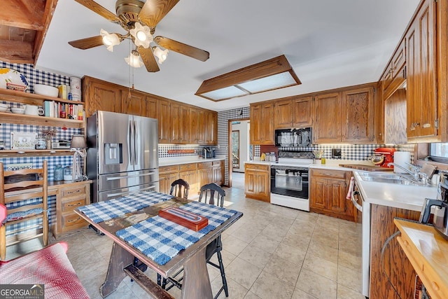 kitchen featuring stainless steel appliances, backsplash, light countertops, and brown cabinets