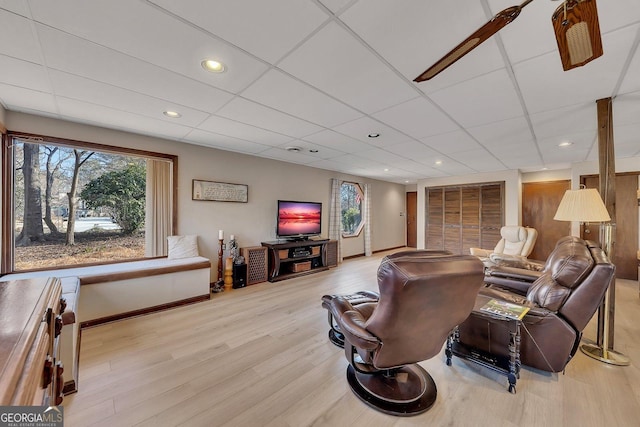 living area with a paneled ceiling, light wood-style floors, baseboards, and recessed lighting