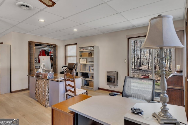 office space with light wood-type flooring, a paneled ceiling, heating unit, and recessed lighting