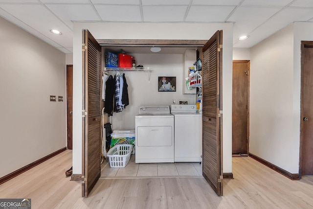 laundry room featuring light wood-type flooring, laundry area, independent washer and dryer, and baseboards