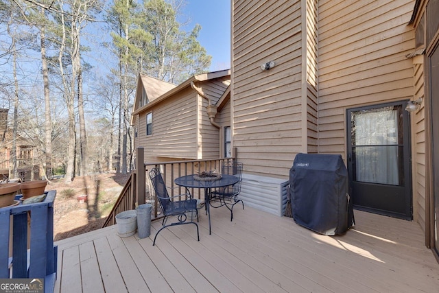 wooden terrace with outdoor dining space and area for grilling