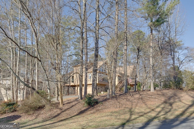 view of yard featuring driveway, stairway, and a carport