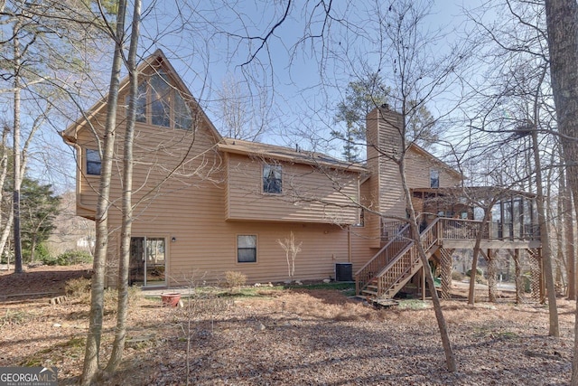 rear view of property with a chimney, stairs, and central AC unit