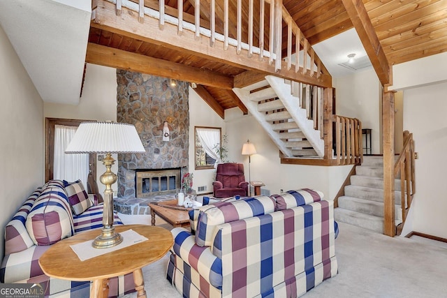 living area featuring wood ceiling, plenty of natural light, a stone fireplace, and beamed ceiling