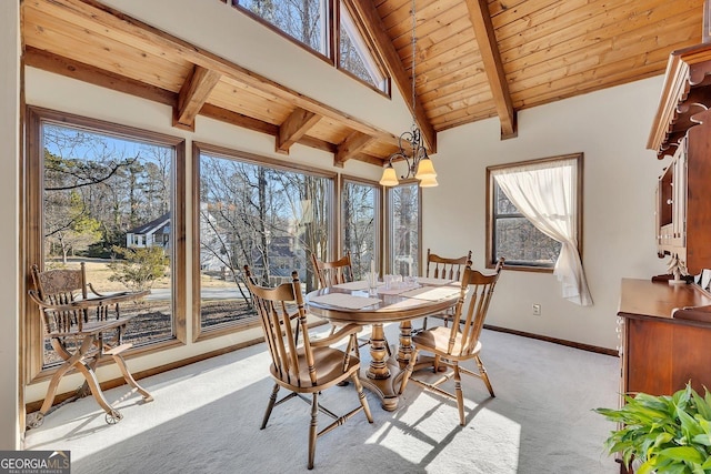 dining space featuring light carpet, wood ceiling, baseboards, and beamed ceiling