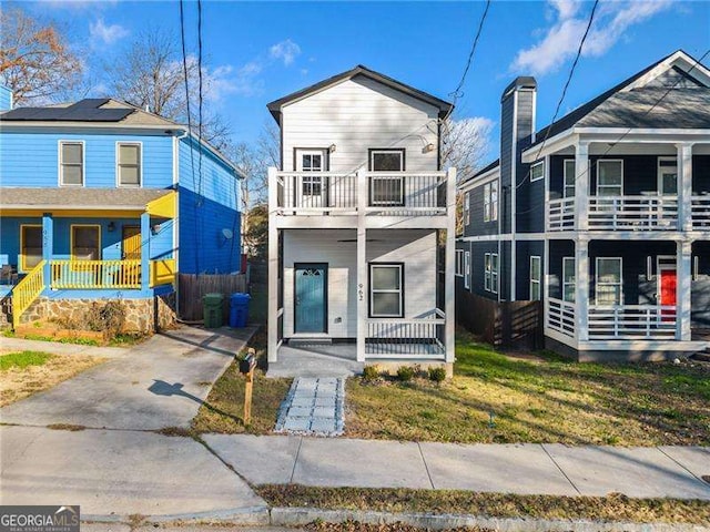 view of front of home featuring a porch, a balcony, and a front lawn