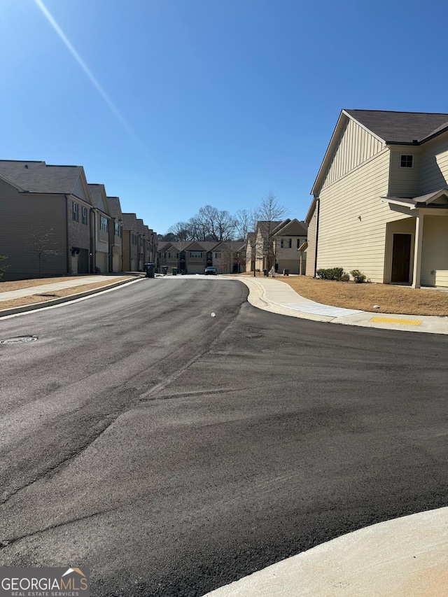 view of street with a residential view, curbs, and sidewalks