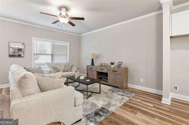 living room featuring ornamental molding, ceiling fan, baseboards, and wood finished floors