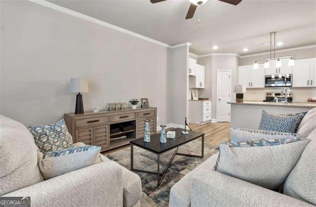 living room featuring recessed lighting, crown molding, light wood-style flooring, and ceiling fan