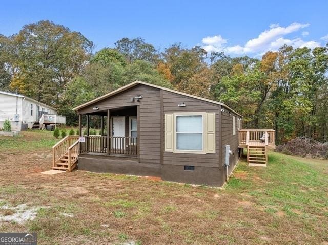 view of front of home featuring crawl space, covered porch, stairs, and a front yard