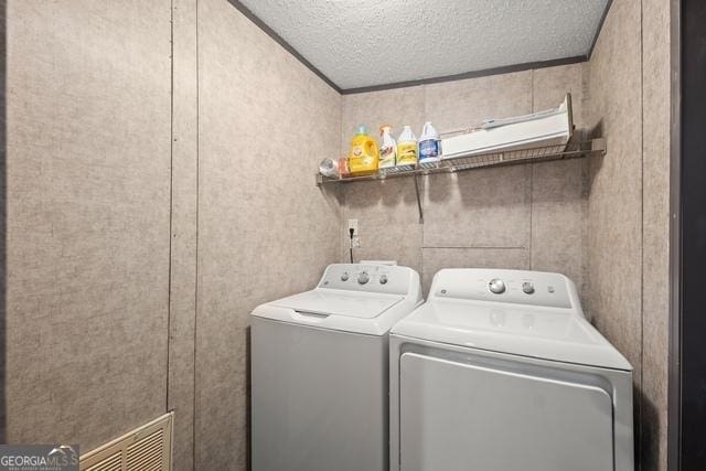 laundry room with laundry area, visible vents, a textured ceiling, and independent washer and dryer