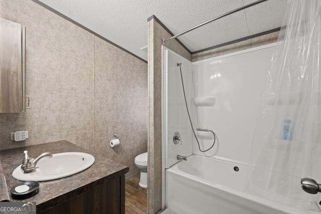 bathroom featuring toilet, vanity, and shower / bathtub combination