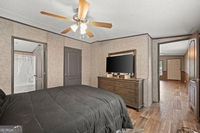 bedroom featuring light wood finished floors, ceiling fan, ornamental molding, and a textured ceiling