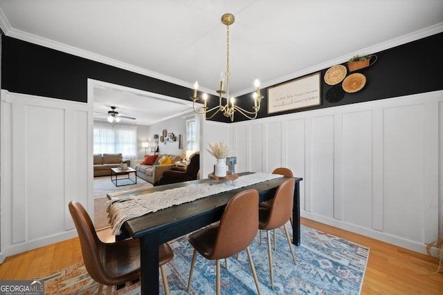 dining space featuring crown molding, a notable chandelier, and light hardwood / wood-style floors