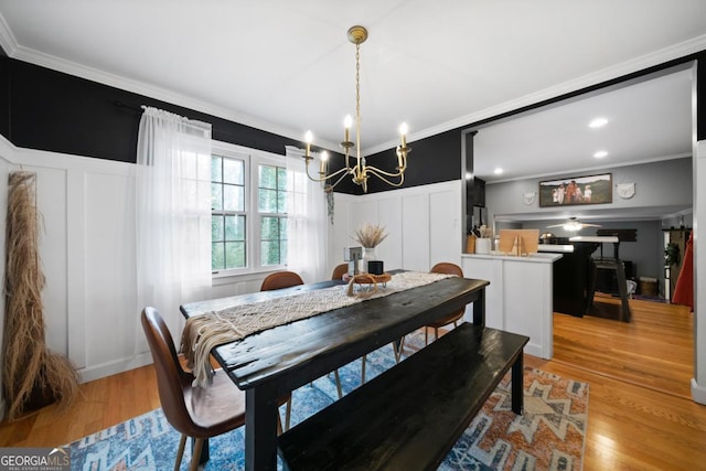 dining area with ornamental molding and light hardwood / wood-style flooring
