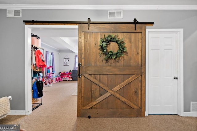 interior space featuring crown molding, carpet flooring, and a barn door