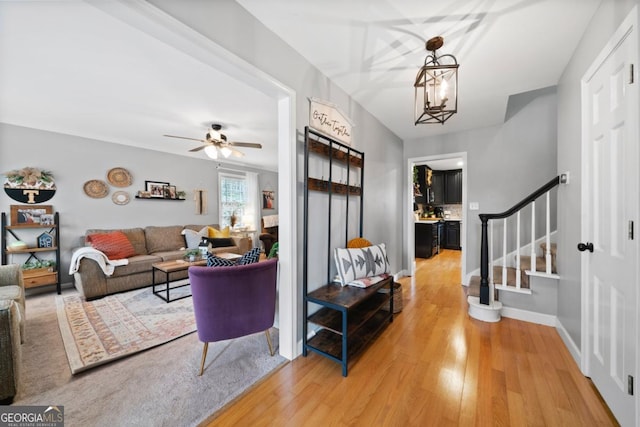 entrance foyer featuring hardwood / wood-style flooring and ceiling fan with notable chandelier