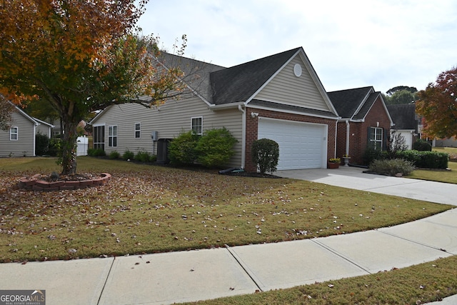 view of side of property with a lawn, driveway, an attached garage, and brick siding