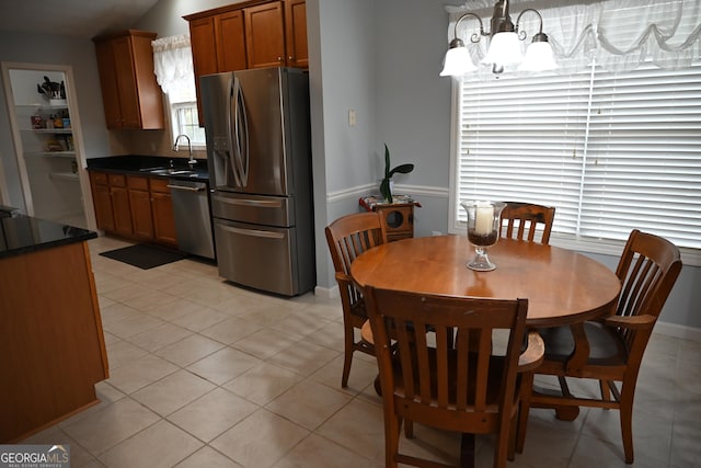 dining room featuring an inviting chandelier, light tile patterned floors, and lofted ceiling