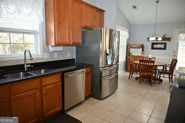 kitchen with a chandelier, a sink, visible vents, appliances with stainless steel finishes, and brown cabinetry