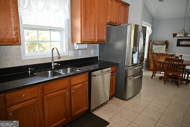 kitchen with stainless steel appliances, tasteful backsplash, sink, and dark stone countertops