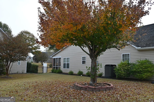 view of property exterior with central AC unit and a yard