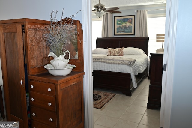 bedroom featuring multiple windows, light tile patterned floors, and ceiling fan