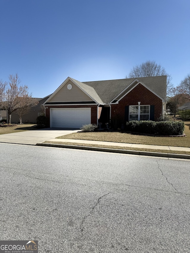 view of front facade with an attached garage, concrete driveway, and brick siding