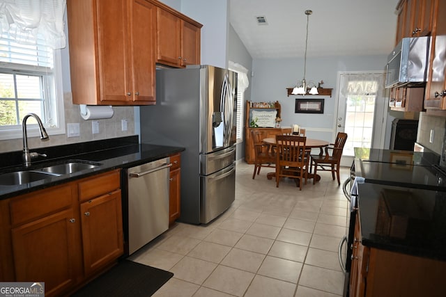 kitchen featuring appliances with stainless steel finishes, decorative light fixtures, sink, decorative backsplash, and light tile patterned floors