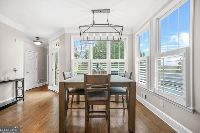 dining area with visible vents, wood finished floors, and ornamental molding