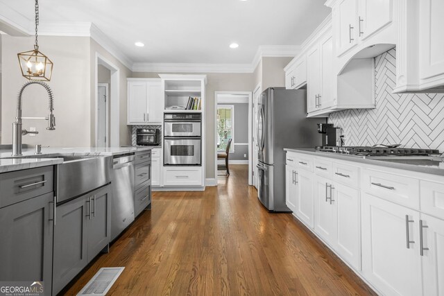 kitchen featuring stainless steel appliances, visible vents, gray cabinetry, ornamental molding, and white cabinetry