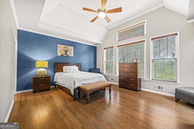 bedroom featuring lofted ceiling, baseboards, visible vents, and wood finished floors