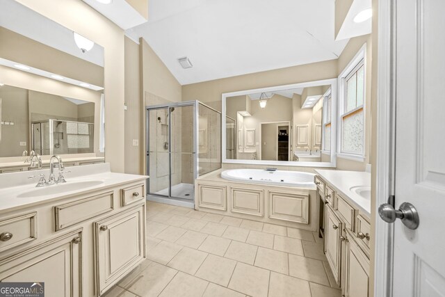 full bathroom with a stall shower, two vanities, vaulted ceiling, and a sink