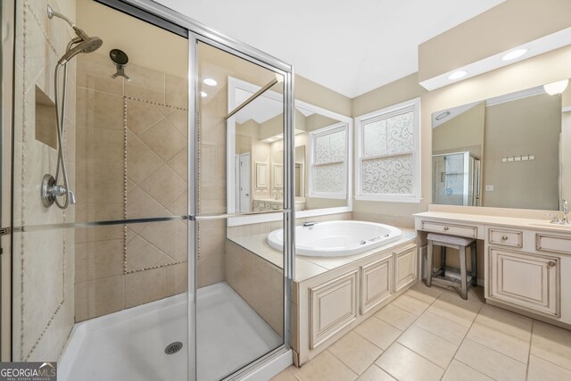 bathroom with a stall shower, a garden tub, vanity, and tile patterned floors